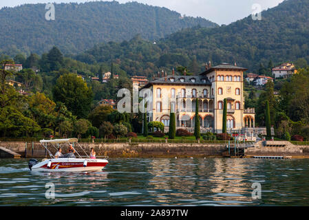 Villa am Meer in der Nähe von Bellagio, während am späten Nachmittag Bootsfahrt am Comer See, Lombardei Italien Europa EU Stockfoto