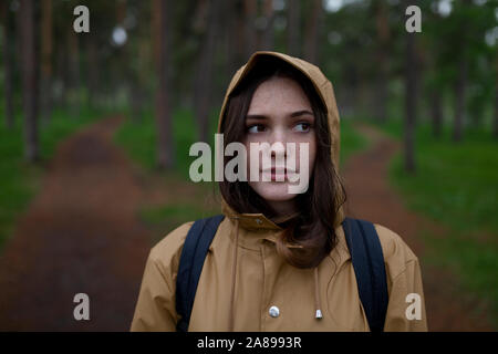 Porträt einer jungen Frau mit braunem Regenmantel Stockfoto