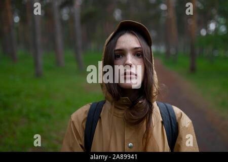Porträt einer jungen Frau mit braunem Regenmantel Stockfoto