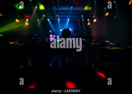 MIC, die Bühne ist BEREIT FÜR DEN Sänger oder Sprecher mit UNSCHARFEN BCKGROUND UND FARBE ZURÜCK. Stockfoto