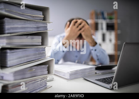 Foto von Gestressten Geschäftsmann tun Steuern im Büro Stockfoto