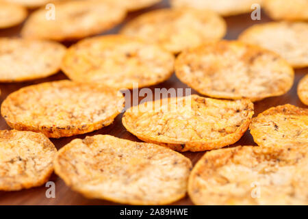 Nahaufnahme des Organischen, knusprige, gebackene, Vollkorn Reis Chips mit Tomaten und Paprika Gewürze. Glutenfreie gesunden Snack auf einem hölzernen Hintergrund. Selektive Stockfoto