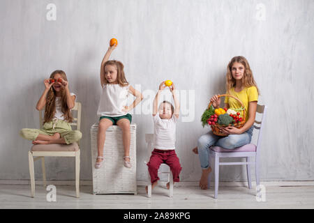 Jungen und drei Mädchen mit einem Korb von Gemüse und Obst Stockfoto