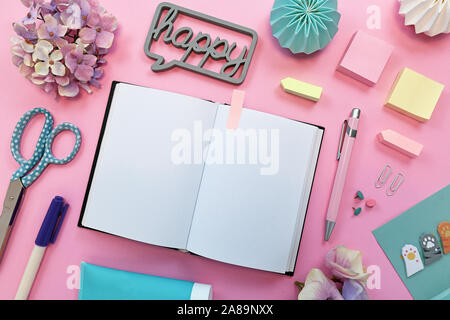 Ansicht von oben flach mit verschiedenen bunten Büromaterial, wie Stifte, Schere, Notizblöcke, Stifte und Öffnen leer Notebook als Platzhalter für Text auf Rosa Stockfoto