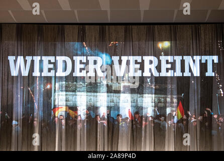 Berlin, Deutschland. 07 Nov, 2019. Die Beschriftung der Veranstaltung 'Wiedervereinigung' ist auf der Vorhang des Kino International bei der Premiere der Film "der Fall der Mauer - ein Jahr, das Geschichte geschrieben" projiziert. Der Film verfolgt das Jahr vom Fall der Berliner Mauer der Wiedervereinigung aus der ursprünglichen Materialien des Spiegel TV-Reporter. Credit: Fabian Sommer/dpa/Alamy leben Nachrichten Stockfoto