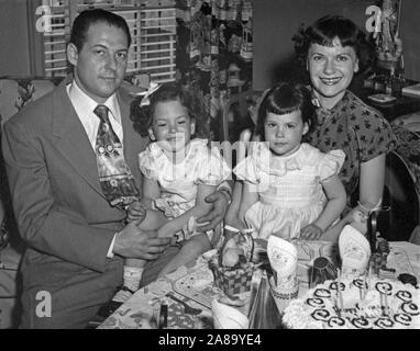 Vintage Familie Fotographie im Jahre 1950 von einer nuklearen Familie mit 2 Töchter, Alter 4 und 5 getroffenen Maßnahmen, eine Geburtstagsparty. Stockfoto