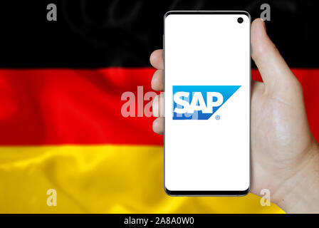 Logo der öffentlichen Unternehmen SAP auf dem Smartphone angezeigt. Flagge Deutschland Hintergrund. Credit: PIXDUCE Stockfoto