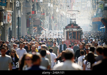 ISTANBUL - Mai 7, 2010: eine Straße Auto macht seinen Weg neben Käufer Drängen der Istiklal Caddesi, der belebtesten Einkaufsstraße im Land. Stockfoto