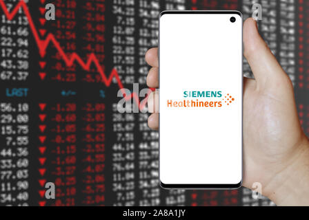 Logo der öffentlichen Unternehmen Siemens Healthineers auf dem Smartphone angezeigt. Negative Börse Hintergrund. Credit: PIXDUCE Stockfoto