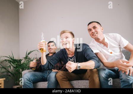 Gruppe von jungen Freunden beobachten Sport Spiel auf Fernsehen Stockfoto