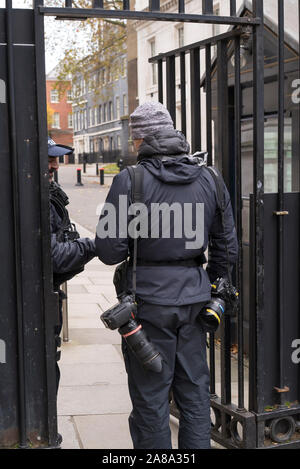 Ansicht der Rückseite des männlichen Fotograf an der Polizei Sicherheit Tor geprüft, bevor Sie in der Downing Street in London während der Wahlkampagne 2019. Stockfoto