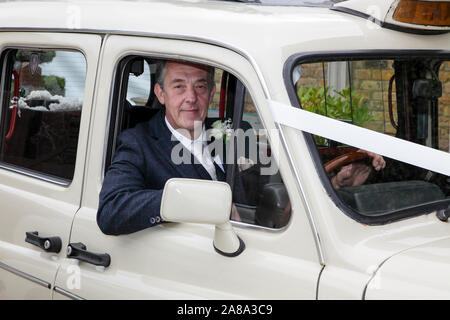 London Taxi Fahrer sitzt in der vorderen seiner Töchter Hochzeit Taxi. Terry selbst ist ein Londoner Taxi Driver (Black Cab). Stockfoto