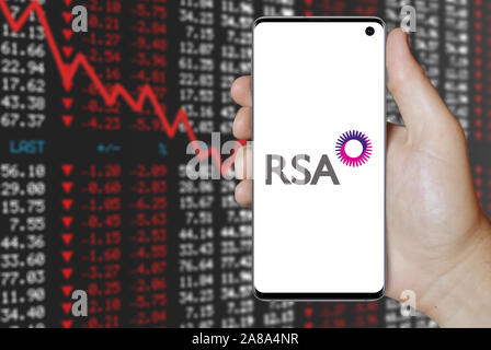 Logo der öffentlichen RSA Insurance Group angezeigt auf einem Smartphone. Negative Börse Hintergrund. Credit: PIXDUCE Stockfoto