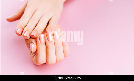 Schöne Frau Hände auf Rosa backgrounda. Spa und Maniküre Konzept. Weibliche Hände mit rosa Maniküre. Weiche Haut Hautpflege Konzept. Beauty Nails. Stockfoto