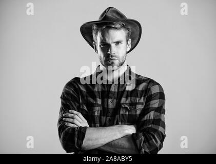 American Cowboy. Schönheit Standard. Beispiel wahrer Männlichkeit. Cowboy Hut tragen. Westliche leben. Mann unrasiert Cowboy beigen Hintergrund. Unrasierten Kerl in Cowboyhut. Schöne bärtige Macho. Stockfoto