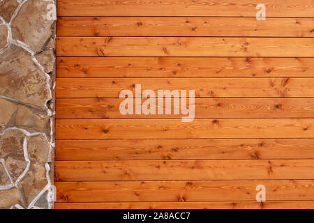 Wunderschöne Wand aus Naturstein und Holz, in der Farbe von Kirschholz lackiert Stockfoto