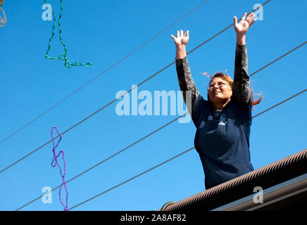 Ein Nachtschwärmer wirft Strings von Perlen in der Masse während des jährlichen Mardi Gras Parade März 6, 2011 in Grand Isle, Louisiana. Stockfoto