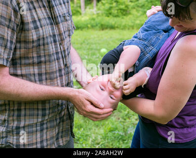 Eine junge Kleinkind spielen mit seinen Eltern. Stockfoto