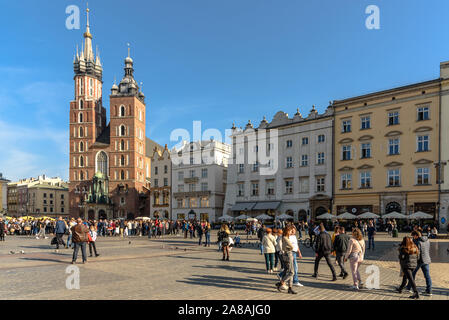 Touristen zu Fuß entlang der Hauptplatz in der Altstadt von Krakau, Polen an einem warmen Herbsttag Stockfoto