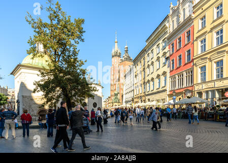 Touristen zu Fuß entlang der Hauptplatz in der Altstadt von Krakau, Polen an einem sonnigen Herbsttag Stockfoto