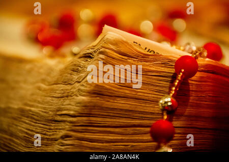 Ecke Seiten eines alten abgenutzte Bibel Buch und einem katholischen Rosenkranz. Stockfoto