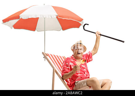 Männliche Touristen mit einem Cocktail und einem Stock in einem Liegestuhl sitzen mit einem Regenschirm auf weißem Hintergrund Stockfoto