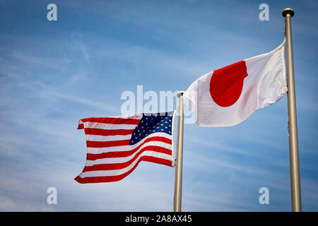 Der amerikanische und der japanische Flaggen fliegen Seite an Seite in Yokosuka, Japan. Stockfoto