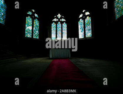 Gewölbte Kirchenfenster Aufleuchten roter Teppich in eine stimmungsvolle Atmosphäre, Seton College Kapelle, Kirche aus dem 16. Jahrhundert, East Lothian, Schottland, Großbritannien Stockfoto