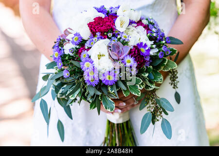 Nahaufnahme eines Braut ihren großen Blumenstrauß mit verschiedenen Blumen und Grün gefüllt halten. Stockfoto