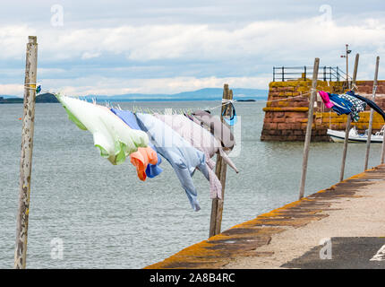 An einem windigen Tag an der Strandpromenade Firth of Forth, North Berwick, East Lothian, Schottland, Großbritannien, hängt Kleidung an einer Wäscheleine Stockfoto