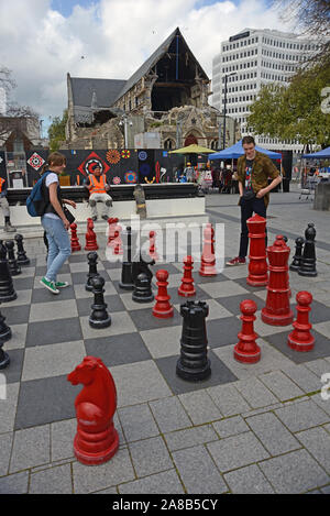 CHRISTCHURCH, NEUSEELAND, Oktober 12, 2019: Ein junges Paar versuchen, ihre Fähigkeiten auf dem riesigen Schachbrett am Cathedral Square Stockfoto