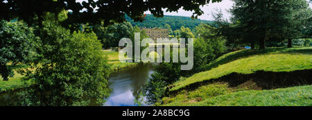 Bäume vor einem Gebäude, Chatsworth House, Fluss Derwent, Derbyshire, England Stockfoto