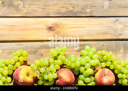 Die ersten Früchte habikkurim in Hebräisch auf Holz- rustikalen Tisch. Symbole der jüdische Feiertag - Schawuot. Weintrauben und Pfirsiche auf Holz vintage Hintergrund. Stockfoto