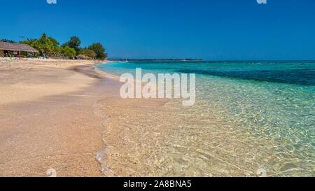 Der Sandstrand und das kristallklare Wasser der tropischen Meer Gili Air, einer der tiefliegenden Gili Inseln Lombok Provinz, in der Nähe von Bali, Indonesien. Stockfoto