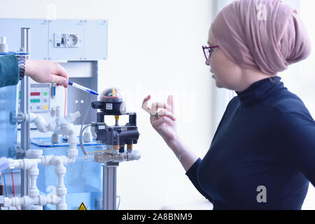 Gruppe von jungen Studenten in technischen Berufsausbildung mit Junge weibliche muslimische Lehrerin Lehrer. Stockfoto