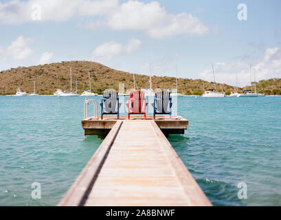 Bunte Liegestühle sitzen auf einem Pier im Bitter End Yacht Club auf Virgin Gorda Island, British Virgin Islands, Karibik Stockfoto