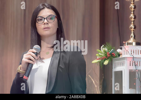 Schöne Geschäftsfrau mit Mikrofon in der Hand in einer Rede auf der Konferenz oder Seminar. Stockfoto