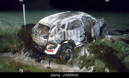 08 November 2019, Niedersachsen, Stuckenborstel: Es gibt einen Ausgebrannten Auto im Feld. (Beste Qualität). Auto ist ein Mann ging in Flammen auf in der Nacht von Freitag auf der Autobahn 1 nach der Kollision mit einem Fahrzeug. Der Mann war in der Lage, sich selbst aus dem brennenden Auto Zu sparen durch seine eigenen Anstrengungen, wie ein Sprecher der Autobahnpolizei am Freitag morgen sagte. Nach ersten Informationen, die SUV-zwischen Bremen und Hamburg gestartet auf gerader Strecke aus bislang ungeklaerter Ursache zu rollen und rammte das Heck. Das Auto wurde dann auf der Seite der Autobahn, wo es sofort Feuer gefangen und geworfen Stockfoto