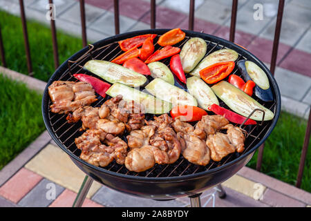 , Grill, beim Mittagessen in der Natur. Sortiment verschiedene Barbecue Grill Fleisch, bbq Party fest, Hähnchen Fleisch Filet, frisches Gemüse, Red p Stockfoto