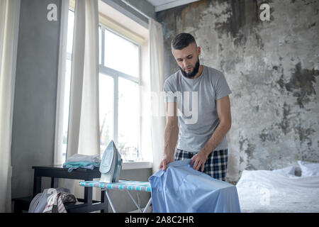 Geschäftsmann sein Hemd bügeln am Morgen Stockfoto