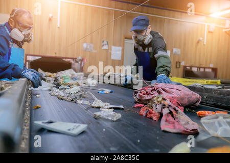 Förderband für das Sortieren von Müll Abfall durch die Menschen. Garbage Verarbeitung. Stockfoto