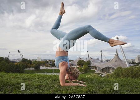 Junge Frau Yoga, Gymnastik, Olympiapark, München, Deutschland Stockfoto