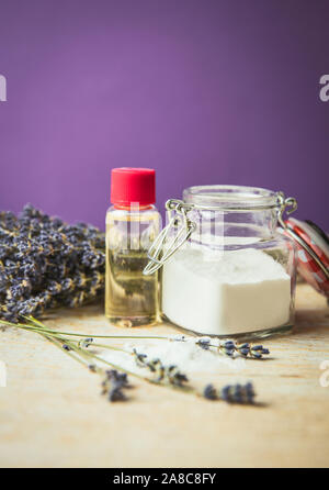 Olivenöl und Natron Gommage Konzept. Hausgemachte natürliche Schönheit Kosmetik. Jar mit Natron Pulver und Flasche mit Olivenöl, lavende Stockfoto