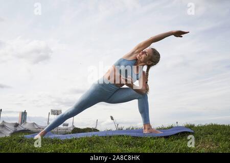 Junge Frau Yoga, Gymnastik, Olympiapark, München, Deutschland Stockfoto