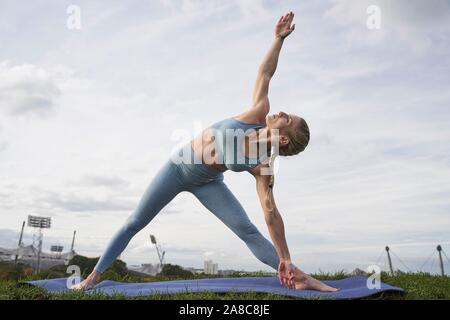 Junge Frau Yoga, Gymnastik, Olympiapark, München, Deutschland Stockfoto