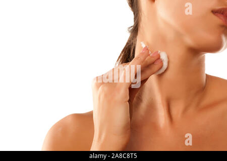 Eine junge Frau Angewandte Kosmetik an ihrem Hals Stockfoto