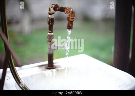 Alten rostigen auf ein Waschbecken mit fließendem Wasser in einem ländlichen Hof tippen Stockfoto