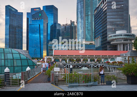 Sicht in der Dämmerung von Clifford Pier, Marina Bay, Singapore, in Richtung der Hochhäuser der zentralen Geschäftsviertel der Stadt Stockfoto