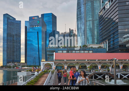 Sicht in der Dämmerung von Clifford Pier, Marina Bay, Singapore, in Richtung der Hochhäuser der zentralen Geschäftsviertel der Stadt Stockfoto