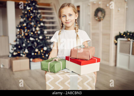 Portrait von kleinen Mädchen mit blonden Haaren auf Kamera halten Geschenksets Sie erhalten Sie vom Weihnachtsmann für Weihnachten Stockfoto